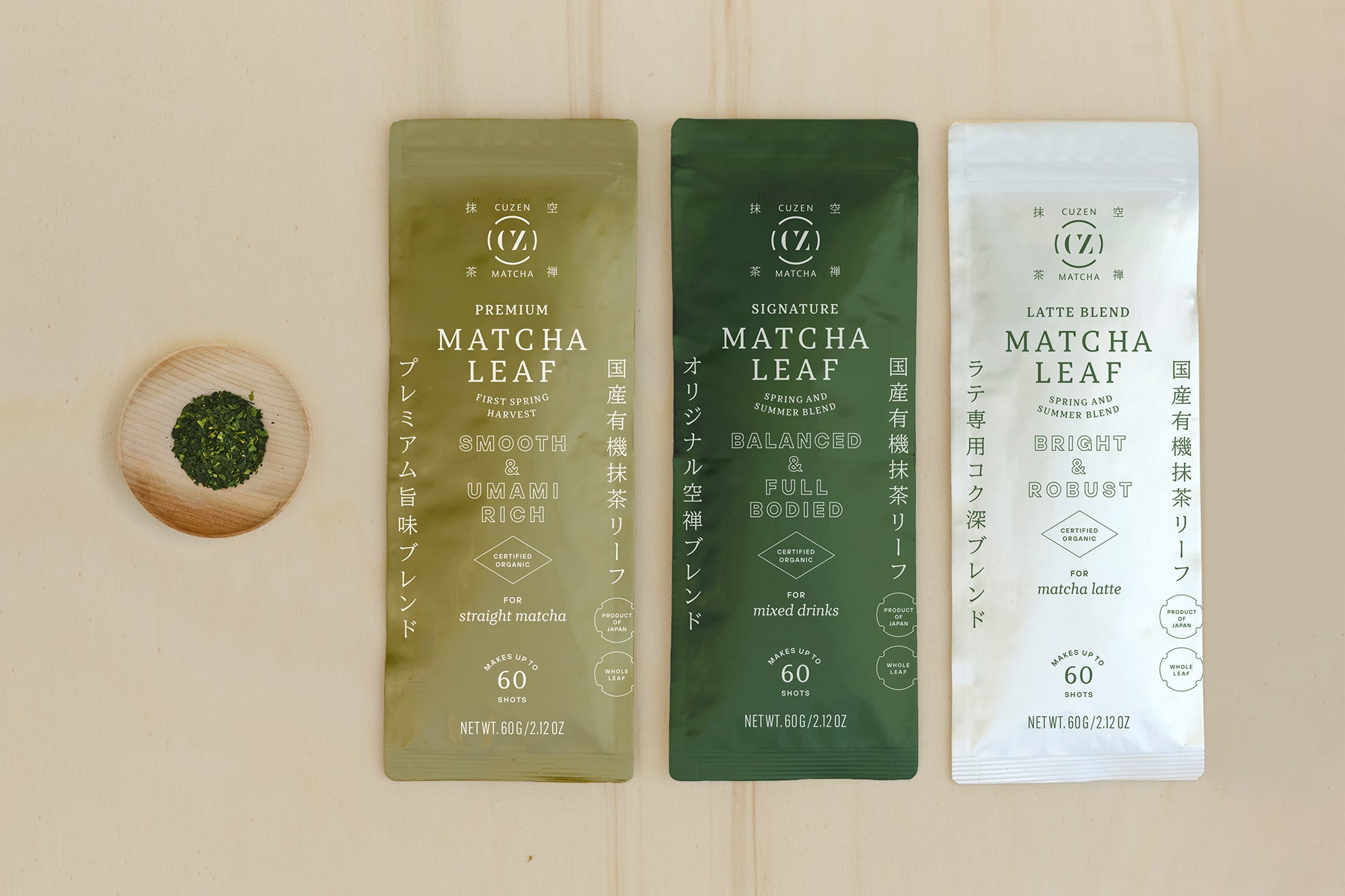 Cuzen’s three standard Matcha Leaf Blends in 60-gram packets, next to a saucerful of deep green, whole matcha leaves.