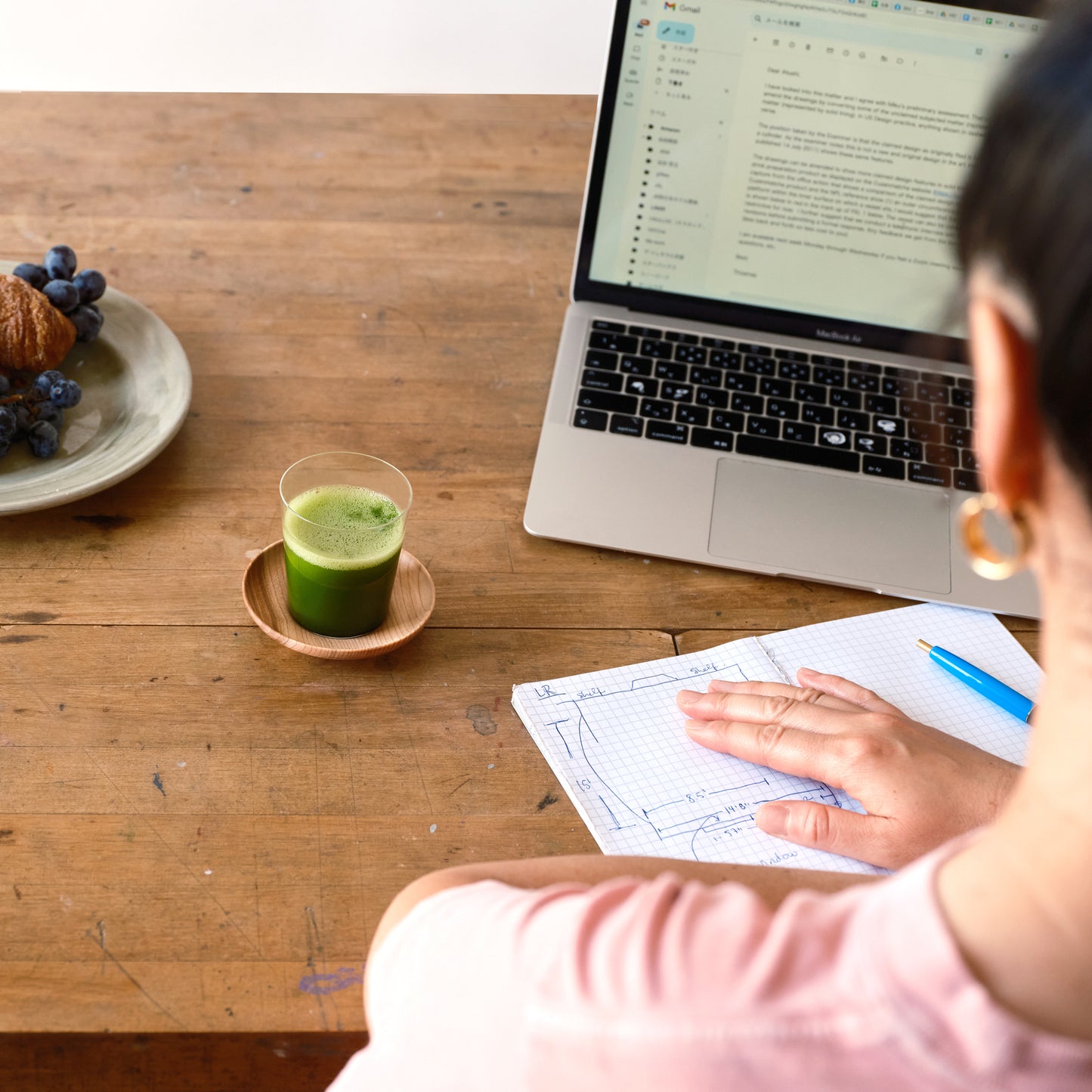 A person works on a computer with a shot of matcha in a Matcha Shot Glass and Saucer.