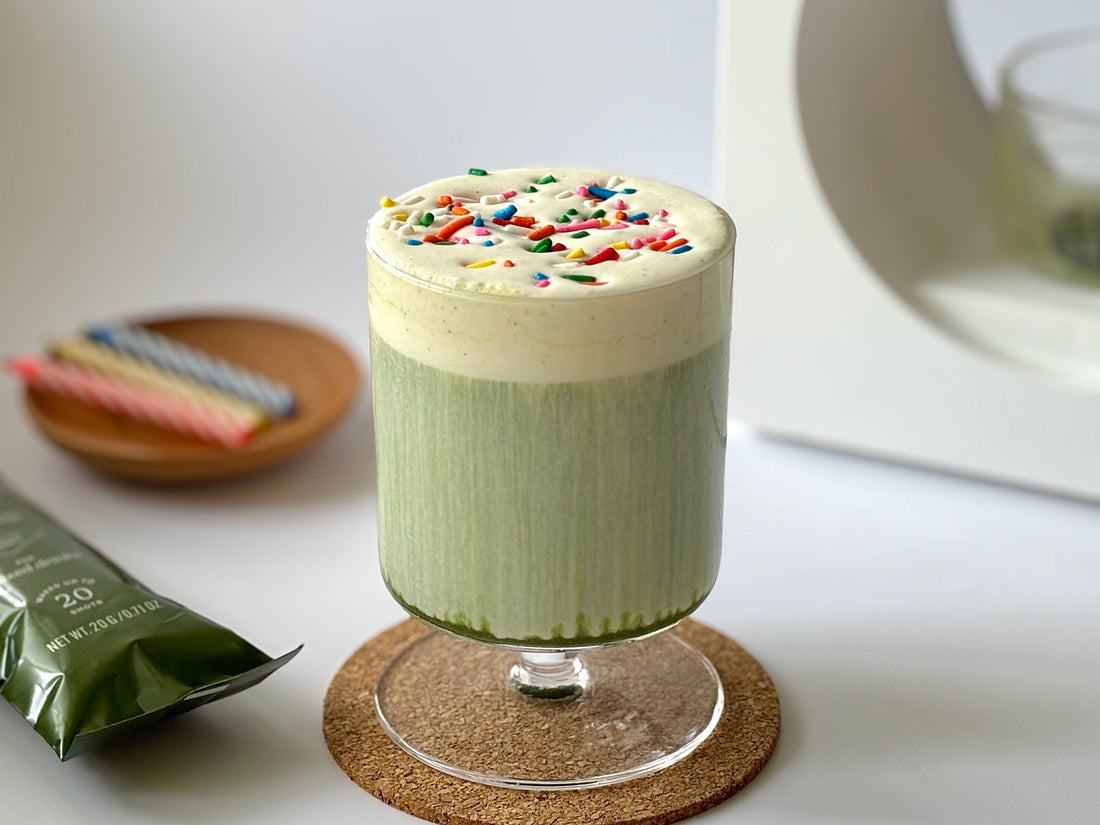 A festive birthday cake matcha latte with cold foam and colorful sprinkles.