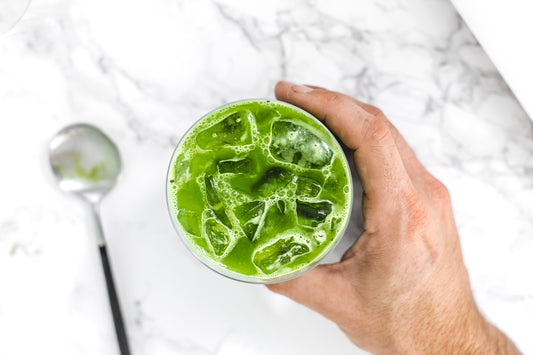 A bird's-eye view of a bright green sparkling matcha in a glass.