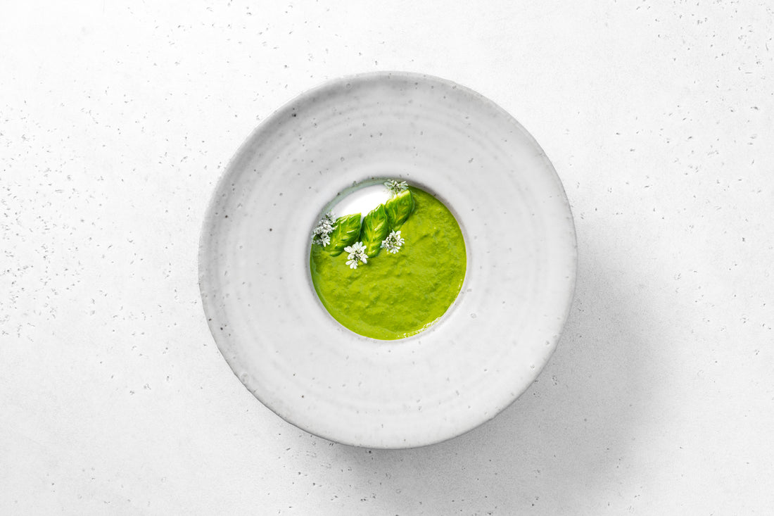 A vivid green, cold soup decked with white flowers, asparagus heads and a dollop of yogurt.