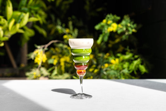 A vivid strawberry matcha latte beautifully displayed in a tiered glass, by SingleThread.