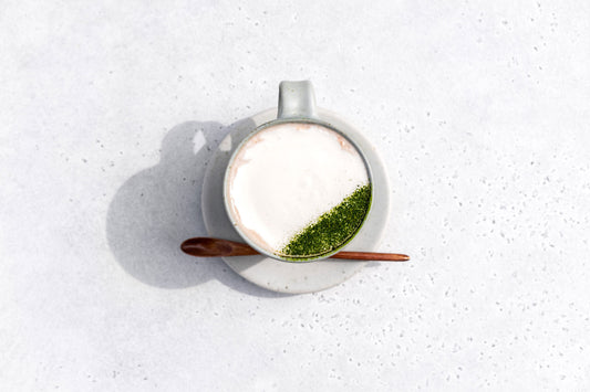 An above view of a matcha hot chocolate with fresh whipped cream and an artistic dusting of matcha powder, by SingleThread.