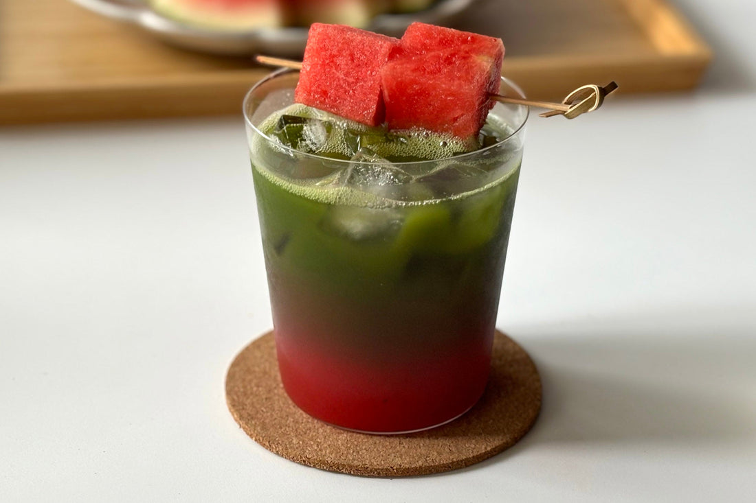 A bright green matcha watermelon refresher with two watermelon pieces, suspended over the cup with a toothpick.