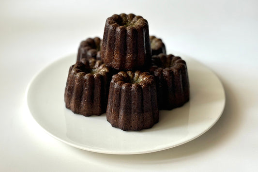 A small plate of five matcha canelè with a Matcha Maker in the background.