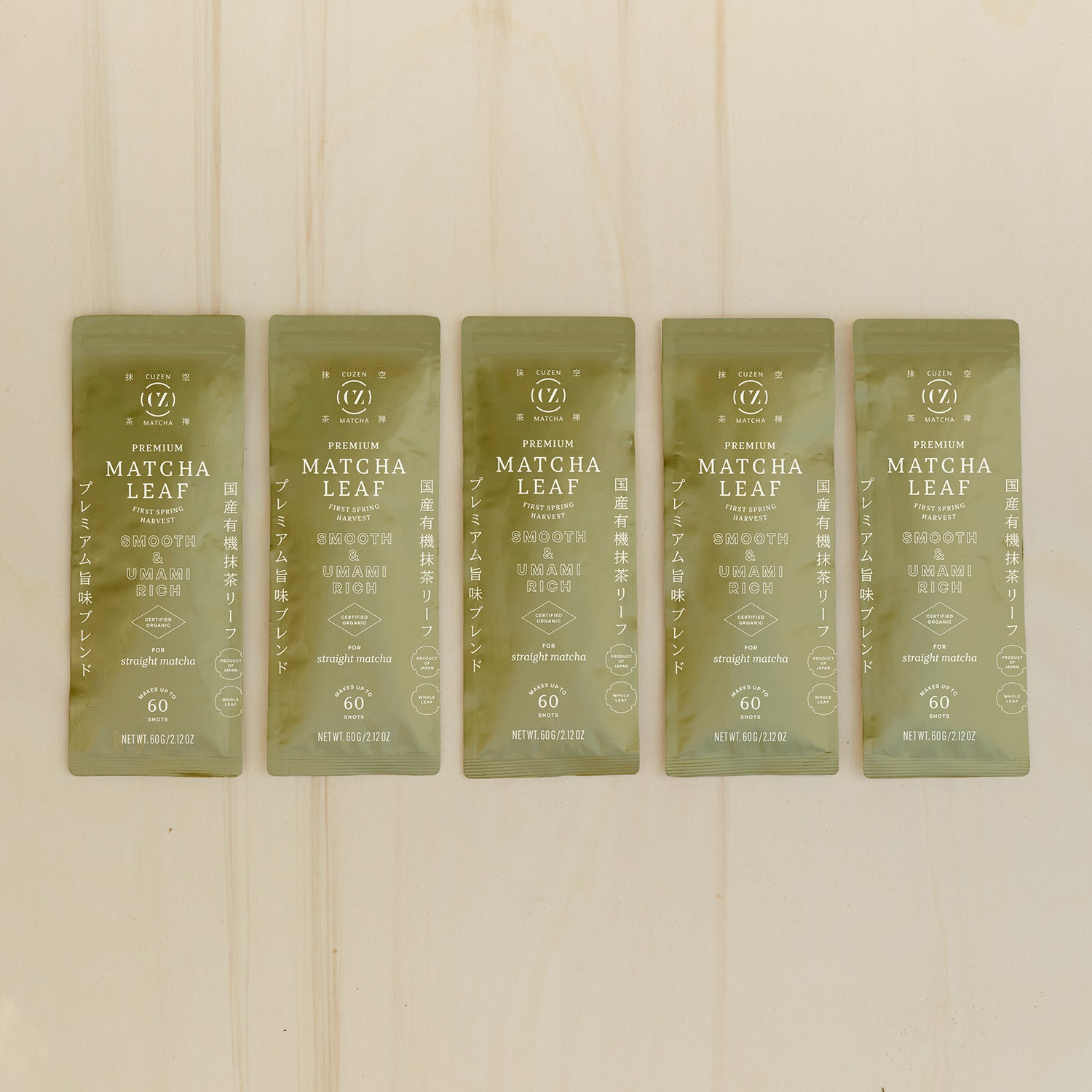 A row of five, gold-colored, 60-gram packets of Cuzen’s Premium Matcha Leaf.