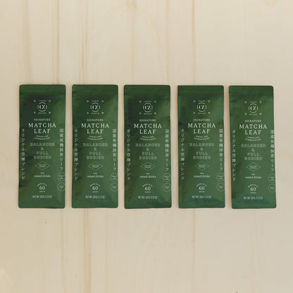 A row of five, green-colored, 60-gram packets of Cuzen’s Signature Matcha Leaf.