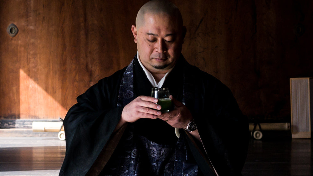 Rev. Takafumi intently holds a glass of sparkling Cuzen Matcha, while demonstrating a five-senses tasting at Shunkoin Temple.