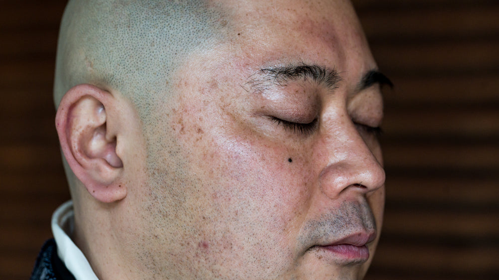 A closeup of Rev. Takafumi, eyes closed, a relaxed countenance, demonstrating a five-senses tasting with Cuzen Matcha.