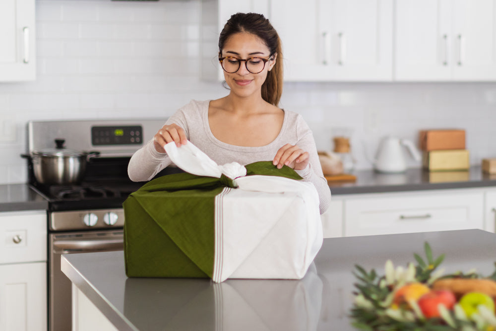 A gift-giver ties the kelp and white-colored furoshiki around the Matcha Maker in a traditional wrapping style.