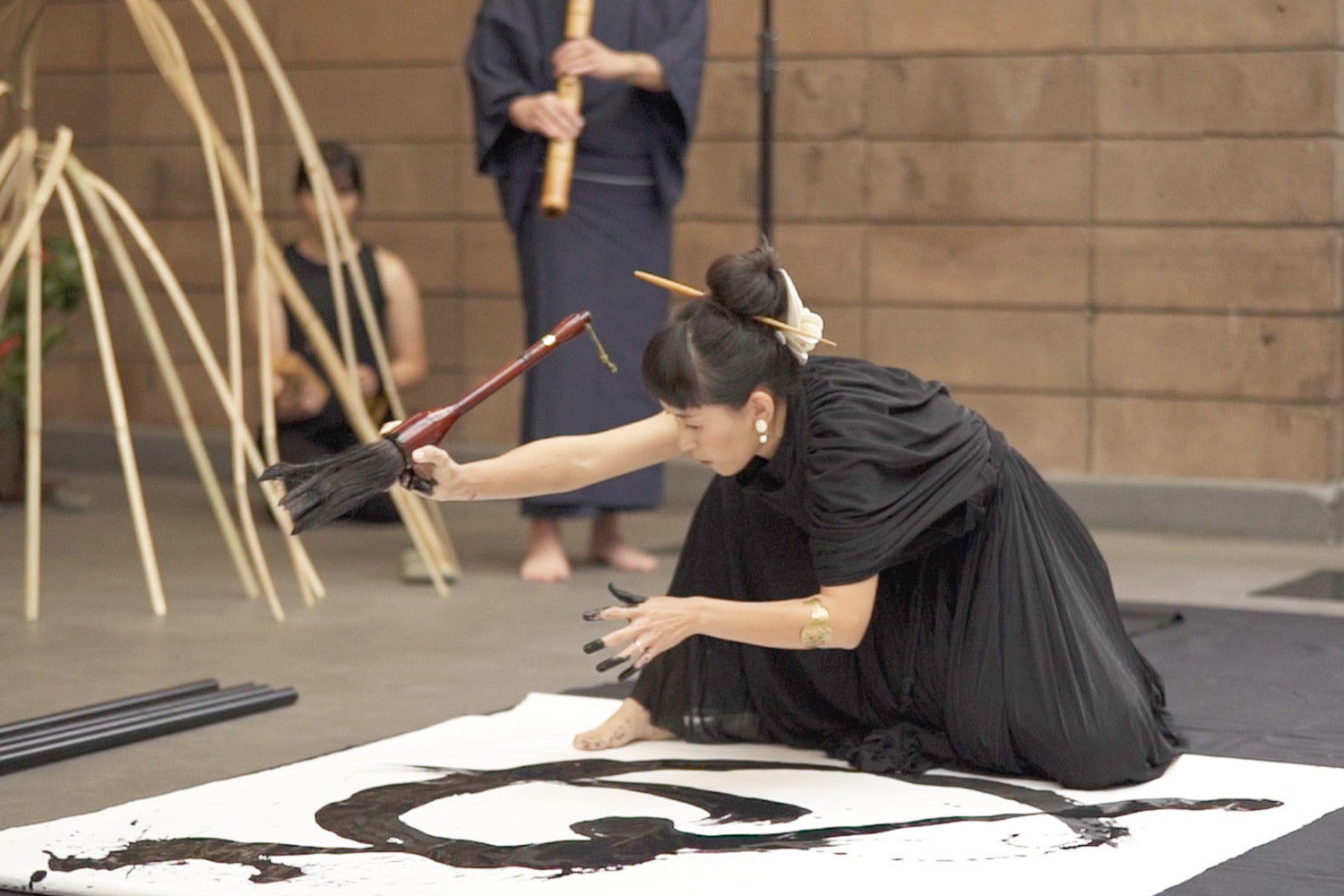 Aoi Yamaguchi opens for a San Francisco “ikebana” exhibit with a live calligraphy performance accompanied by a “shakuhachi.”