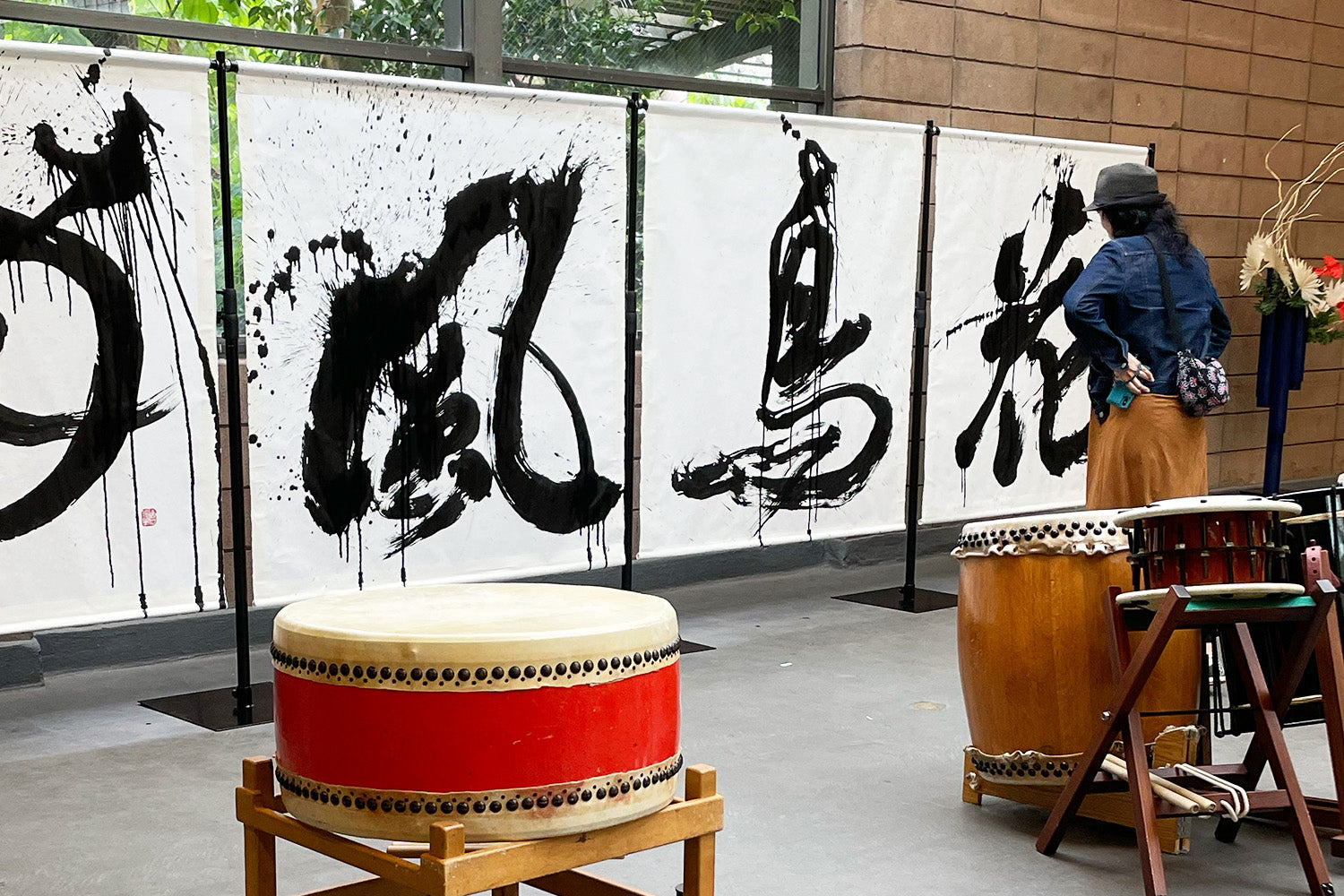 A performance-goer for a San Francisco “ikebana” exhibit admires a huge calligraphy piece, painted in-person by Aoi Yamaguchi’s during the event.