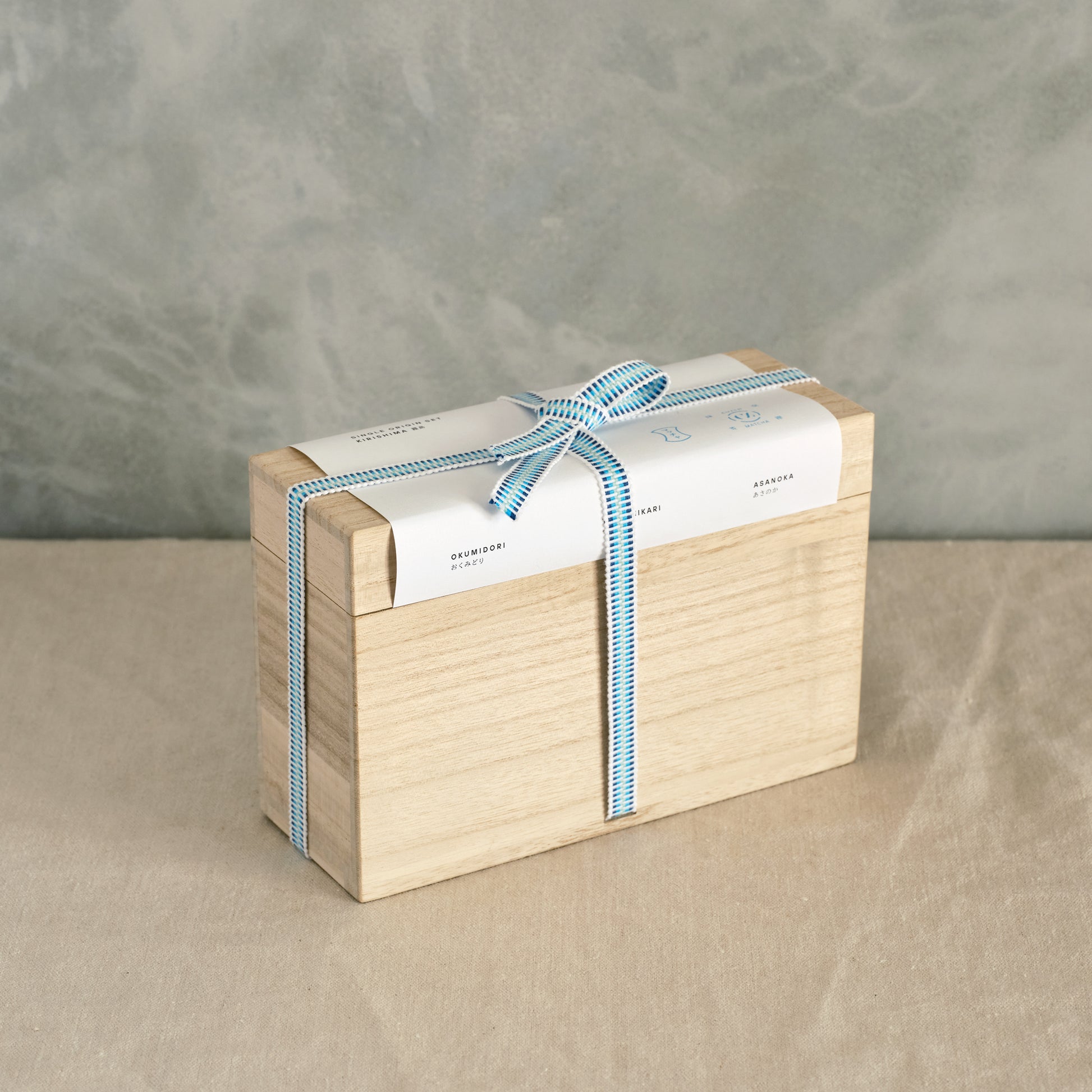 The Single Origin Box Set wrapped in a kiri bako, tied with a blue ribbon.