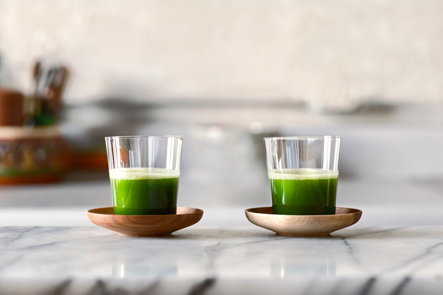 Bright green matcha shots in two sets of Cuzen’s Matcha Shot Glass and Wooden Saucer.
