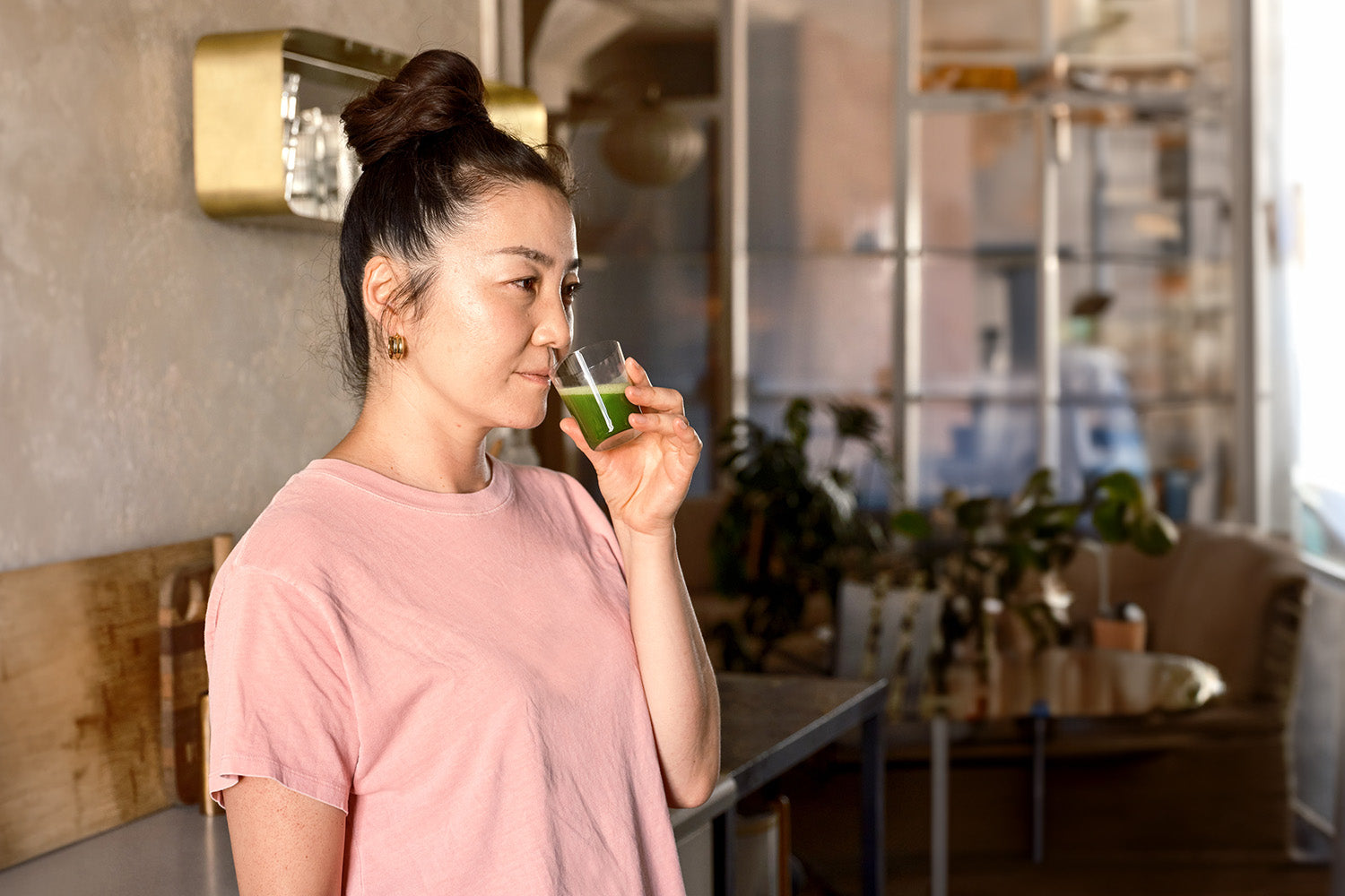 A person takes in the vegetal aroma of a sparkling matcha made with freshly-ground matcha leaves.