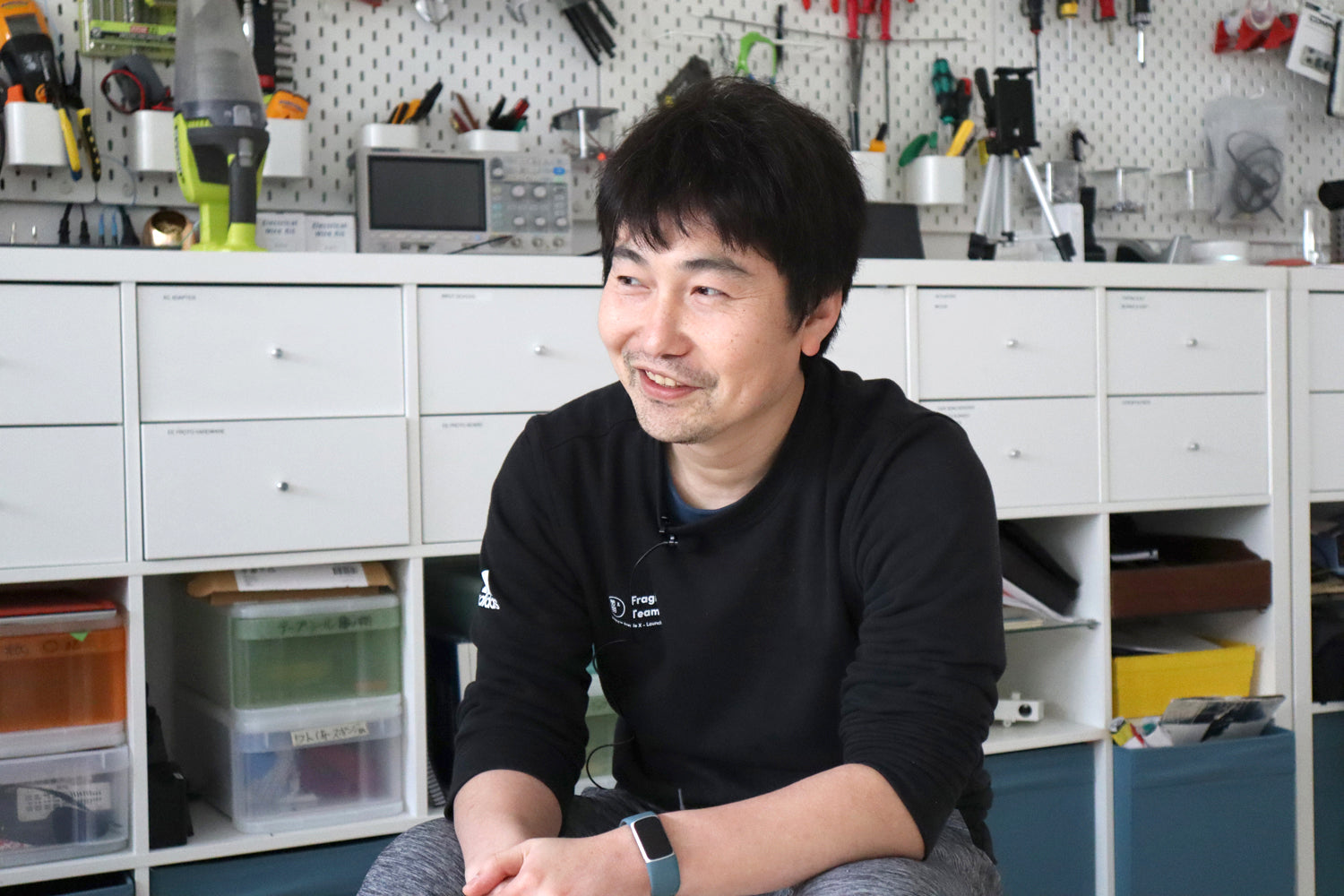 Matcha Maker engineer, Naoto, smiles during a Cuzen interview, his tools behind him.