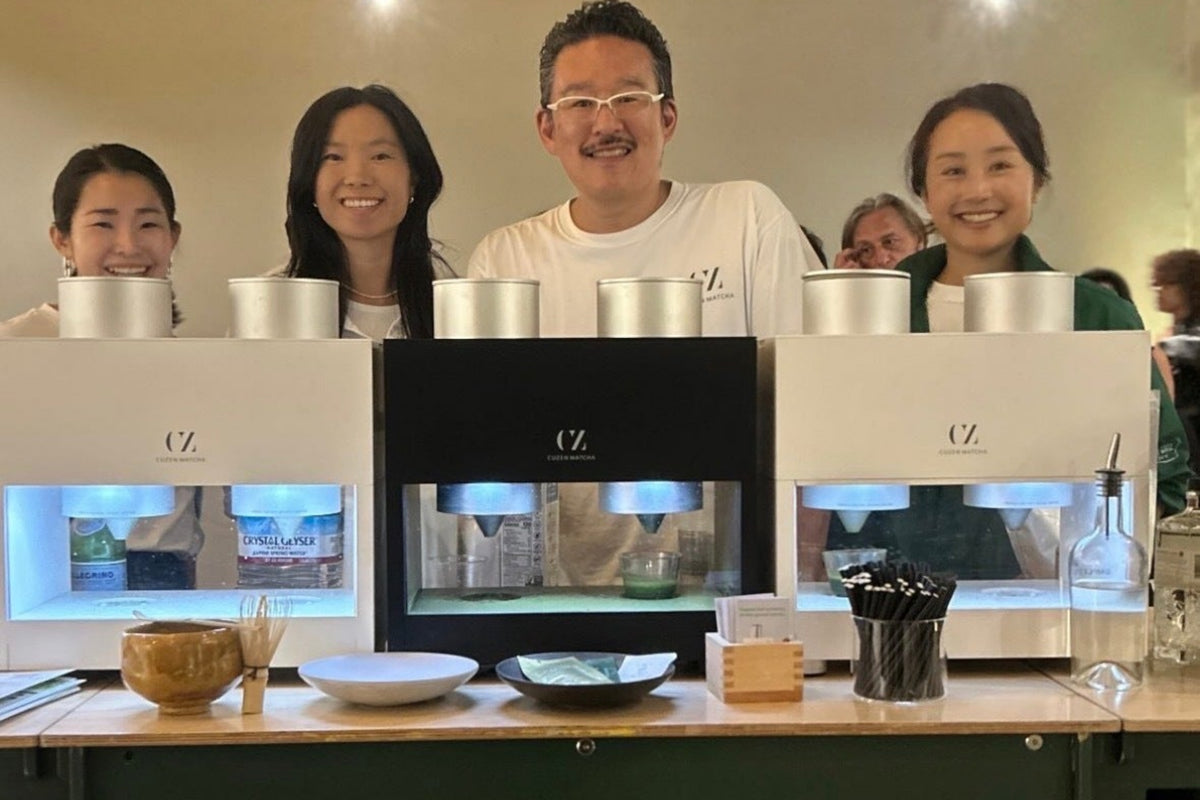 Eijiro and Cuzen team members stand smiling behind three Matcha Maker Pro machines at the San Francisco Design Awards.