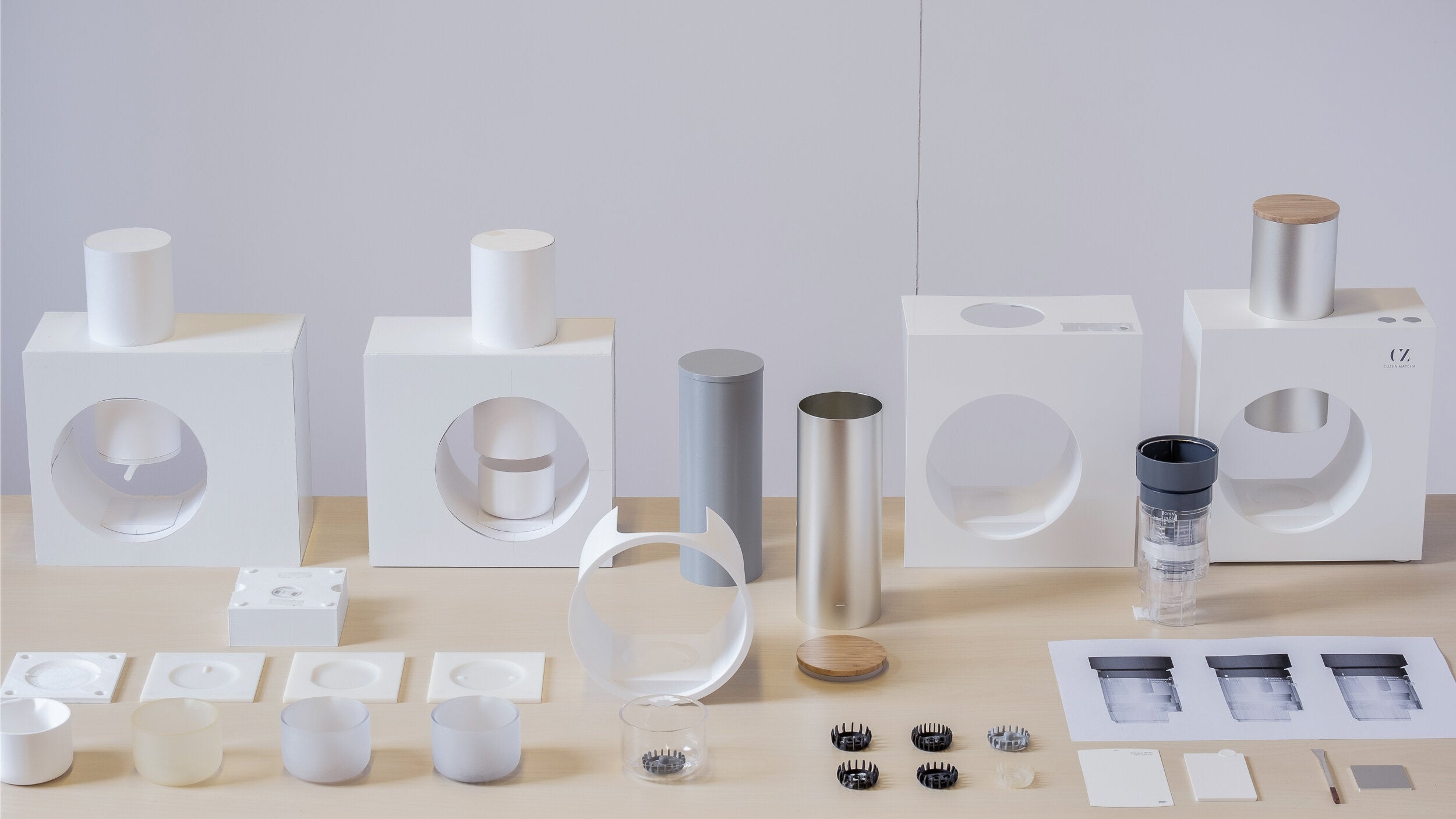 A display of Cuzen Matcha Maker design prototypes, part prototypes and images.