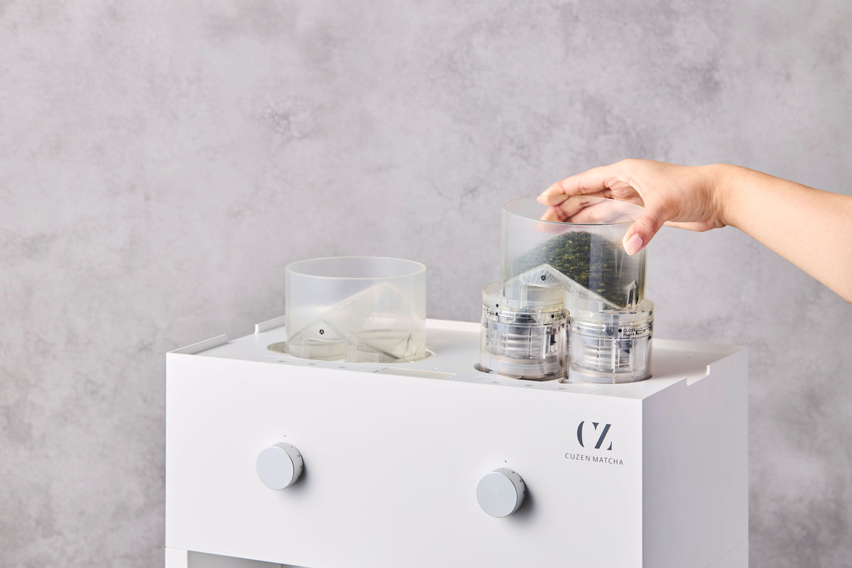 A barista slips the mill unit, filled with Cuzen Matcha Leaf, back into the top of the Matcha Maker Pro.
