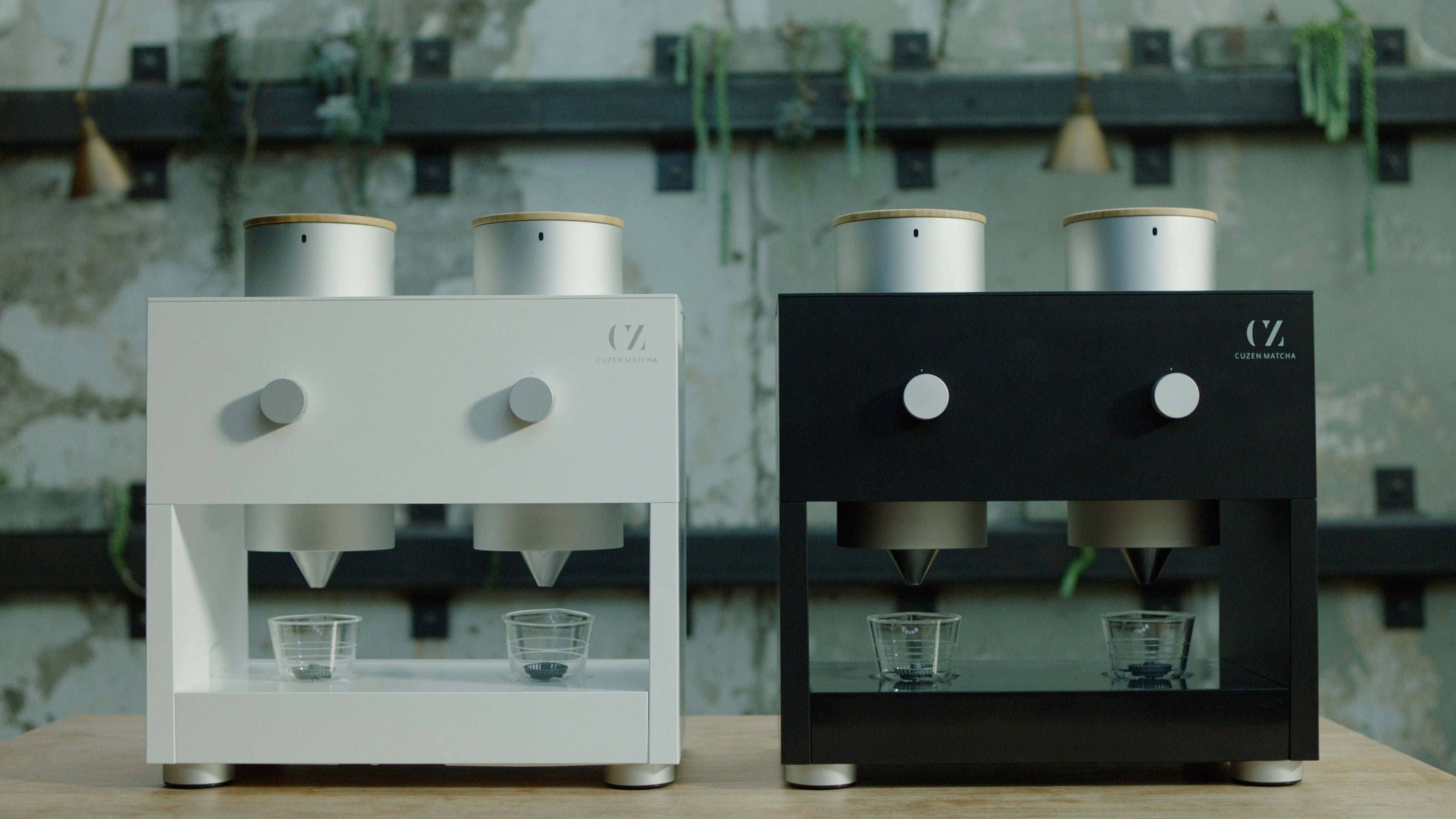 One white and one black Matcha Maker Pro in a cafe space.