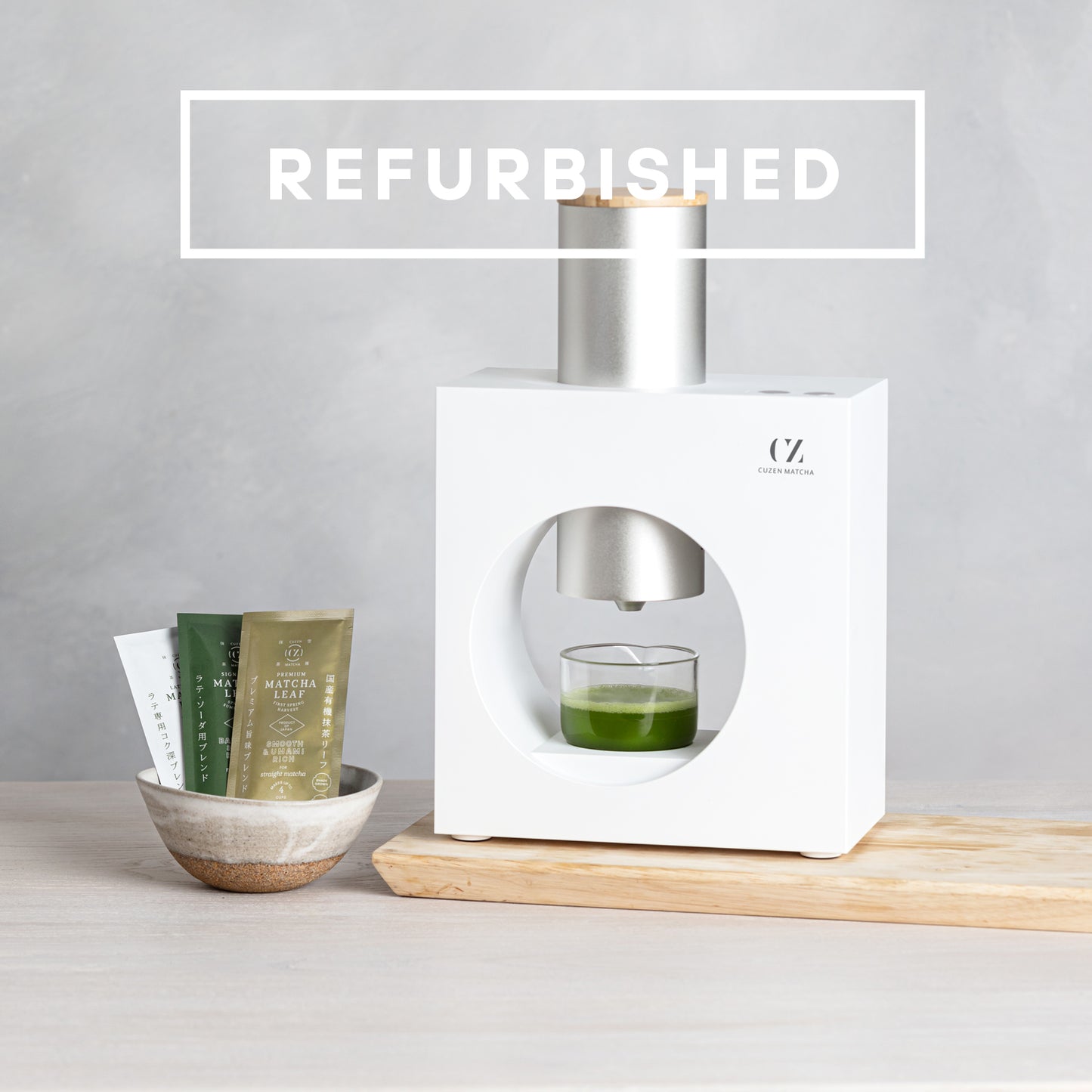 Refurbished Matcha Maker and a bowl of Matcha Leaf sample packets. Overlaid copy reads "REFURIBISHED."