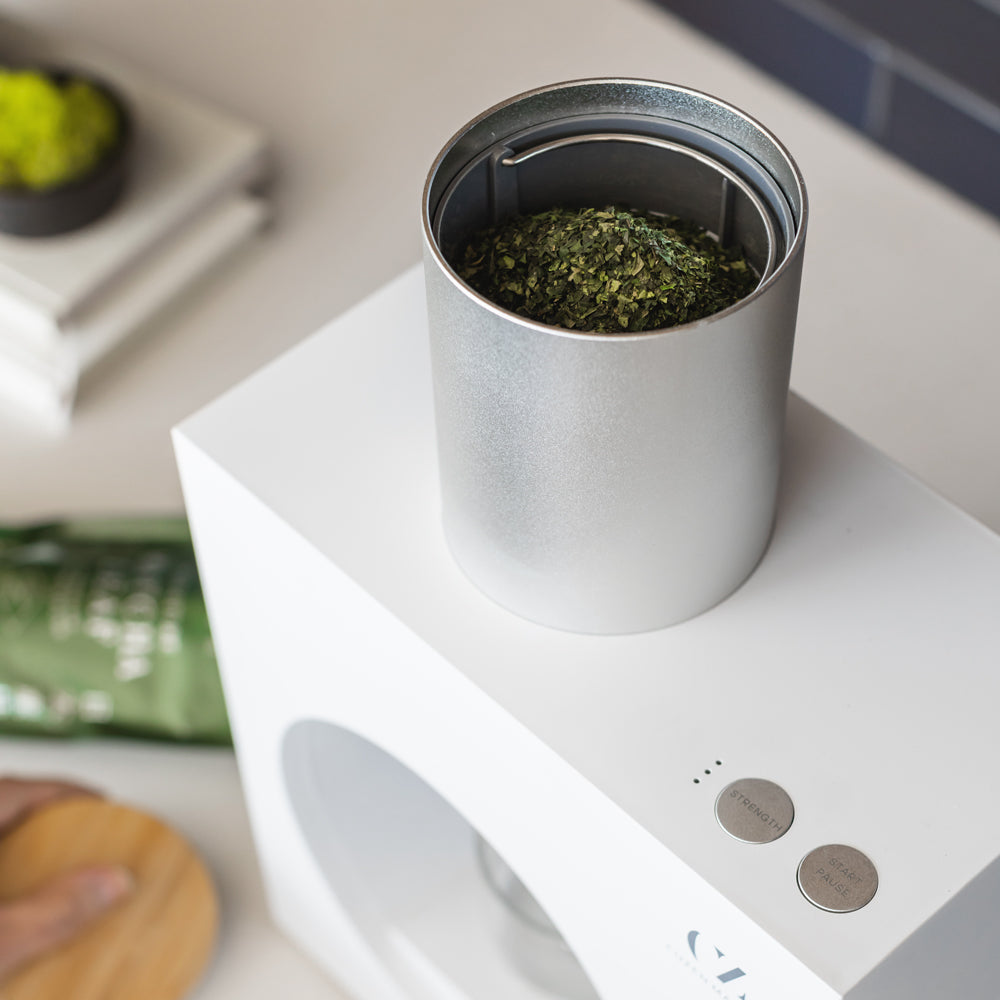 The Matcha Maker’s full hopper, next to the control panel which includes indicator lights and “strength” and “start” buttons.